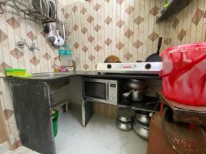 Una pequeña cocina con fregadero y microondas. en Stay near Chittaranjan Hospital Park Circus 2, en Calcuta