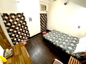 una pequeña habitación con una cama y una mesa en Stay near Chittaranjan Hospital Park Circus 2, en Calcuta