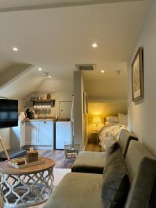 a living room with a couch and a bed at Stables at The Black Horse Inn in Gloucester