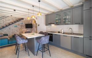 une cuisine avec des armoires grises et une table et des chaises dans l'établissement Awesome Home In Jesenice With Kitchen, à Jesenice