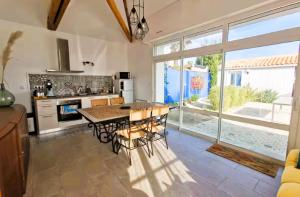 a kitchen with a table and chairs and a large window at La Fleur de Sel in Les Sables-d'Olonne +24 photos