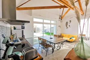 a living room with a table and a couch at La Fleur de Sel in Les Sables-d'Olonne