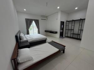 a bedroom with two beds and a window in it at 万里望 Menglembu Bestari Homestay in Menglembu