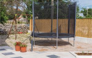 a trampoline in a batting cage in a yard at Three-Bedroom Holiday Home In Unesic in Unešić