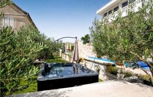 a bath tub in a garden next to a pool at Nice Home In Trogir With House Sea View in Trogir
