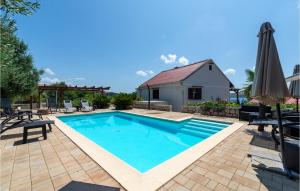 a swimming pool in a yard with chairs and an umbrella at Holiday Home Rtina 24 in Rtina