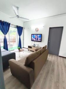 a living room with a couch and a flat screen tv at IRDINA HomestayMuslim's 2 at Emerald Avenue Brinchang Centrum in Brinchang