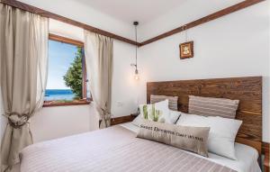 sypialnia z łóżkiem i dużym oknem w obiekcie 1 Bedroom Cozy Home In Moscenicka Draga w mieście Mošćenička Draga
