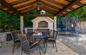 patio ze stołem i krzesłami pod drewnianym dachem w obiekcie Four-Bedroom Holiday Home In Grubine w mieście Grubine