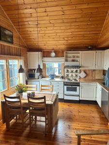 a kitchen with a wooden ceiling and a table and chairs at Convenient ski in-out on Norefjell in the alpine village in Surteberg