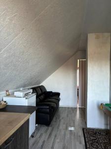 a living room with a black leather couch at Elen in Goliševa