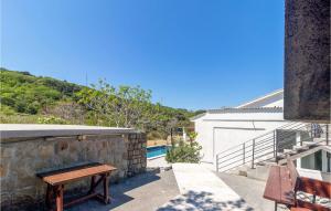 a stone wall with a bench next to a building at 4 Bedroom Awesome Home In Mundanije in Mundanije