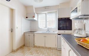 eine Küche mit weißen Schränken und einer Spüle in der Unterkunft 2 Bedroom Cozy Home In Royan in Royan