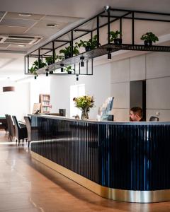 a man sitting at a counter in an office at Dosłońce Resort Wellness & Farm in Racławice