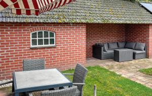 a patio with a table and chairs in a brick building at Amazing Home In De Moer in De Moer