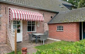 a patio with a table and chairs in a brick house at Amazing Home In De Moer in De Moer