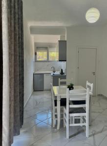 a kitchen and dining room with a table and chairs at Xhefri's Apartments in Vlorë +112 photos