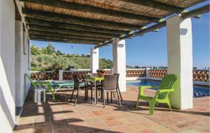 a patio with a table and chairs and a pool at 2 Bedroom Amazing Home In Frigiliana in Frigiliana