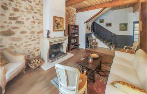 a living room with a fireplace and a staircase at Lovely Home In Cazouls-Lès-Béziers in Cazouls-lès-Béziers