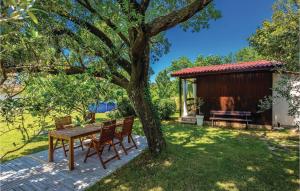a table and chairs under a tree in a yard at Pet Friendly Home In Smrika With Wifi in Šmrika +28 photos