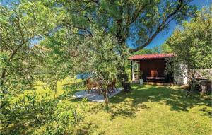 a garden with a table and chairs in front of a cabin at Pet Friendly Home In Smrika With Wifi in Šmrika