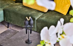 two birds sitting on a stand in front of a couch at 3 Bedroom Nice Apartment In Marina in Marina