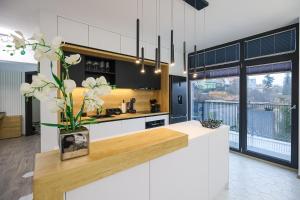 a kitchen with white cabinets and a vase with white flowers at Luxury Landing 8-centrally located accomodation with private parking Targu Mures in Târgu-Mureş
