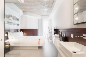 Un dormitorio con una cama blanca y un lavabo. en Ruby Molly Hotel Dublin, en Dublín