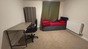 a room with a desk and a bed with a red blanket at Barnsley Guesthouse in Barnsley