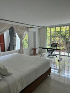 比亚维森西奥TREEHOUSE1959 HOTEL的卧室配有一张床、一张书桌和窗户。