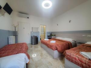 pokój hotelowy z dwoma łóżkami i lodówką w obiekcie Hotel Emmy w Mediolanie