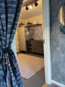 a view of a kitchen from a room with a curtain at Haere Mai B&B Orust in Henån