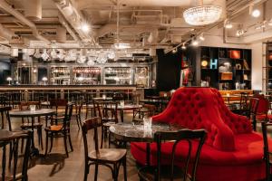 un restaurante con mesas y sillas y un sofá rojo en Ruby Lissi Hotel Vienna, en Viena