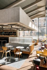 デュッセルドルフにあるRuby Luna Hotel Dusseldorfのソファ、テーブル、椅子が備わるレストラン