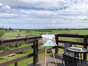 a painting sitting on a deck with a table and chairs at Elen in Goliševa