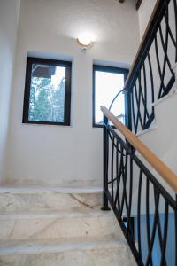 a room with a staircase and two windows at Хотелски комплекс Релакс in Rudozem