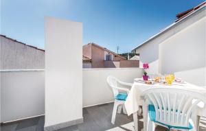 a small balcony with a table and chairs on it at 1 Bedroom Nice Apartment In Vrbnik in Vrbnik +25 photos