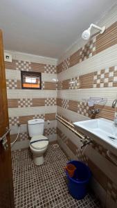 a bathroom with a toilet and a sink at Little Bricks Reverside Villa by GreenEscapes in Vythiri