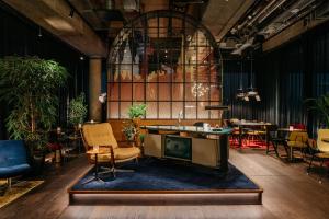 una hall con sedie, tavoli e una TV di Ruby Ella Hotel Cologne a Colonia