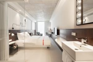 una camera d'albergo con un letto e un lavandino di Ruby Ella Hotel Cologne a Colonia
