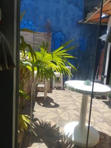 a patio with two tables and chairs and plants at Alugo casa com piscina in Praia Grande