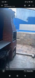 a window view of a patio with a brick wall at Alugo casa com piscina in Praia Grande