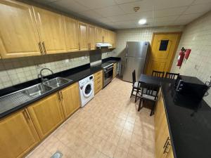 迪拜Backpackers heaven ! 18 beds in a 2 bedroom apartment in front of Union metro station Diera Dubai的一间带水槽和洗碗机的小厨房