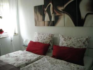 a bedroom with a bed with red pillows at Sahneschnittchen in Hage