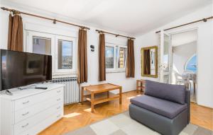 a living room with a tv and a chair at 2 Bedroom Awesome Apartment In Pag in Pag