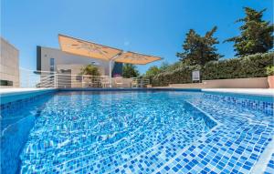 a large swimming pool with a umbrella on top of it at Amazing Apartment In Novalja With Wifi in Novalja +28 photos