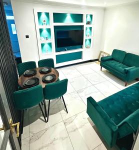 ein Wohnzimmer mit einer Couch und einem Tisch und Stühlen in der Unterkunft Your Home Away, Luxury House in Swansea