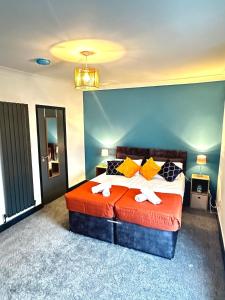 ein Schlafzimmer mit einem Bett mit orangefarbener Bettwäsche und gelben Kissen in der Unterkunft Your Home Away, Luxury House in Swansea