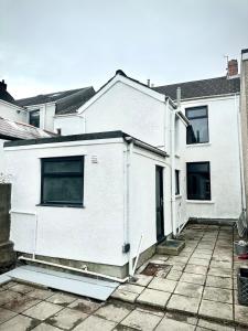 ein weißes Haus mit einem Innenhof davor in der Unterkunft Your Home Away, Luxury House in Swansea