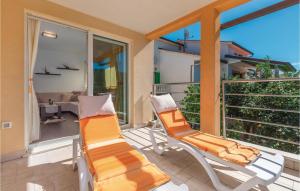 a balcony with two chairs and a living room at Apartment Labin Lxxxi in Labin